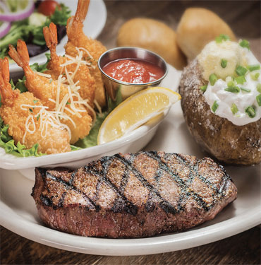 Photo of steak and shrimp with a baked potato